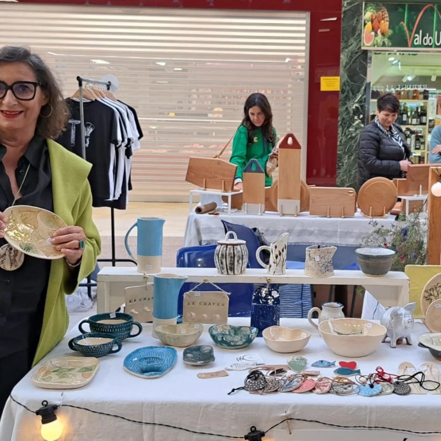 Marta con un plato decorativo en un mercado artesanal