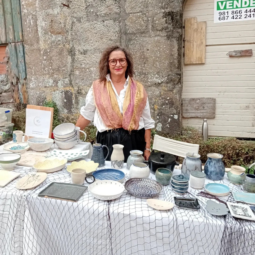 Marta junto a su mesa de cerámica en un mercado al aire libre